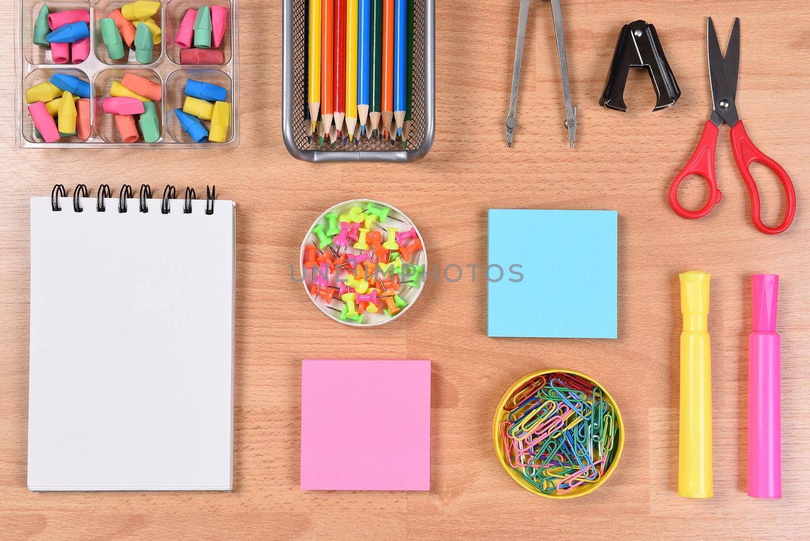 Colorful Back to School Supplies arranged on a wood desk top.