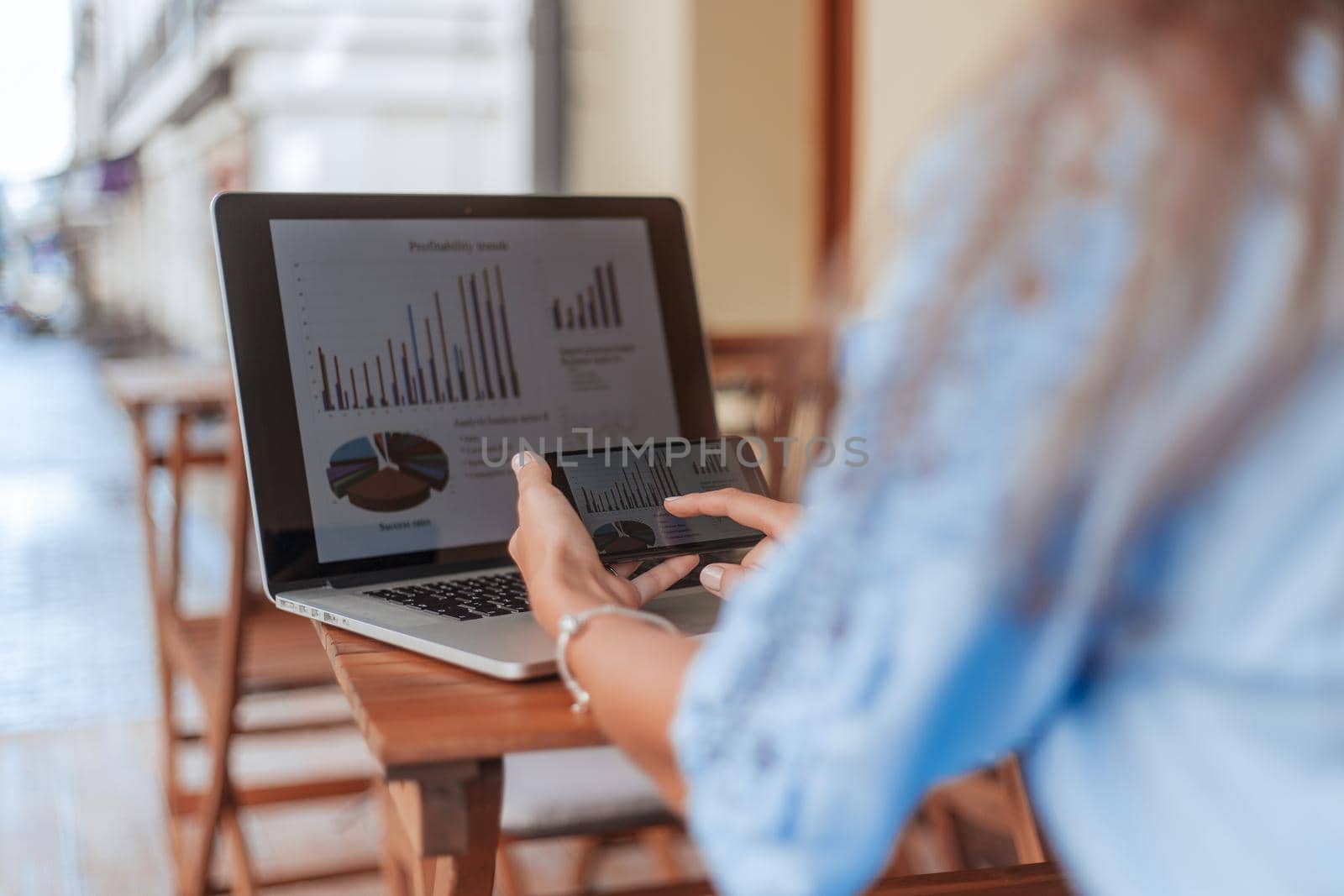 businesswoman with a smartphone analyzing financial data. by SmartPhotoLab