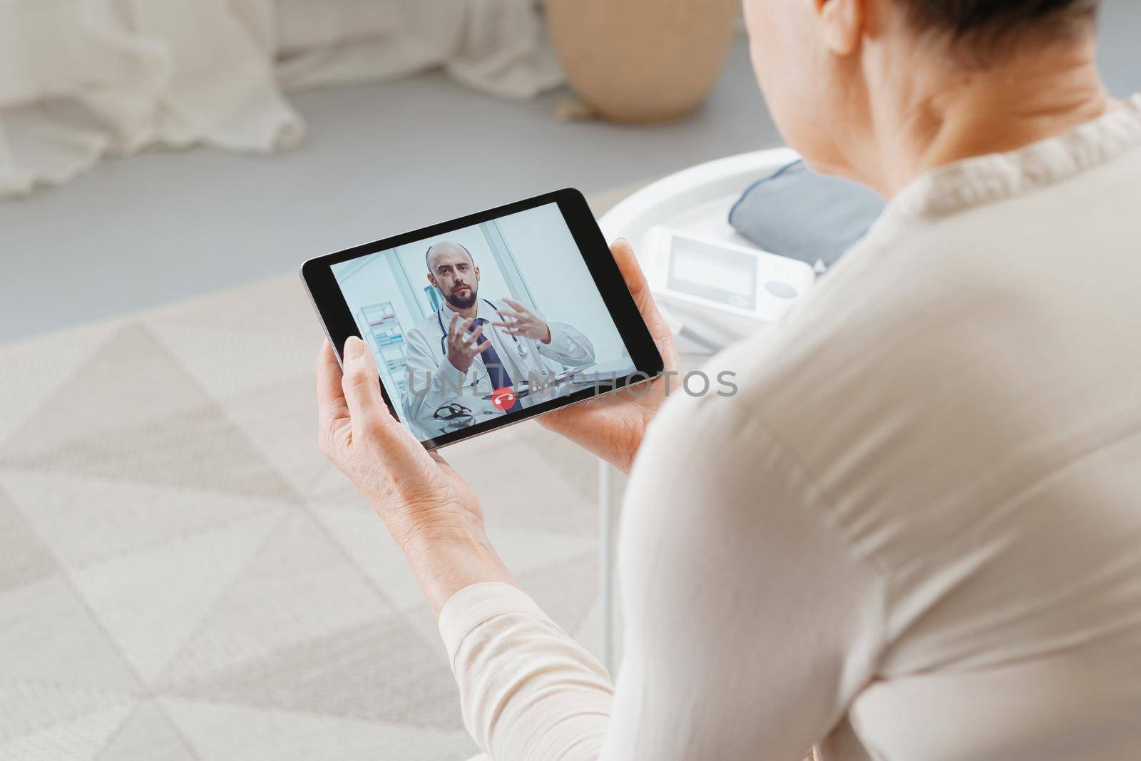 rear view. sick woman consulting a doctor by video link.