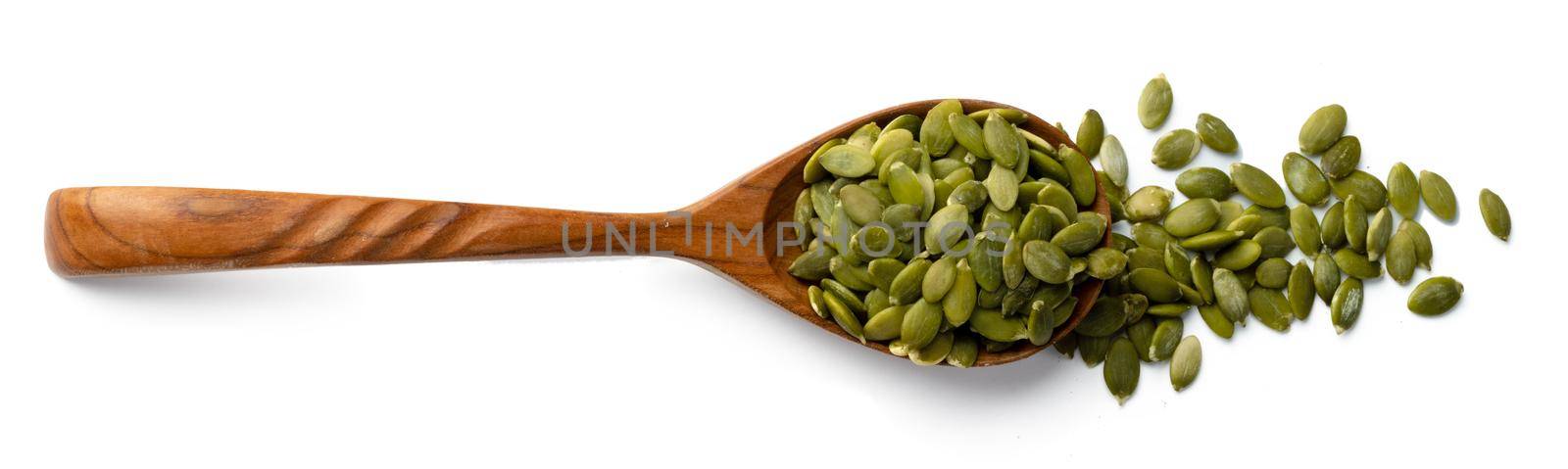 Wooden spoon with raw pumpkin seeds isolated on white background
