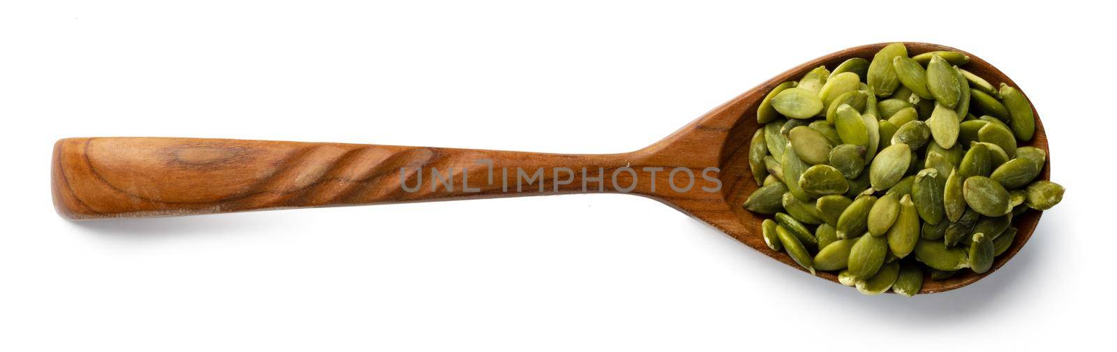 Wooden spoon with raw pumpkin seeds isolated on white background