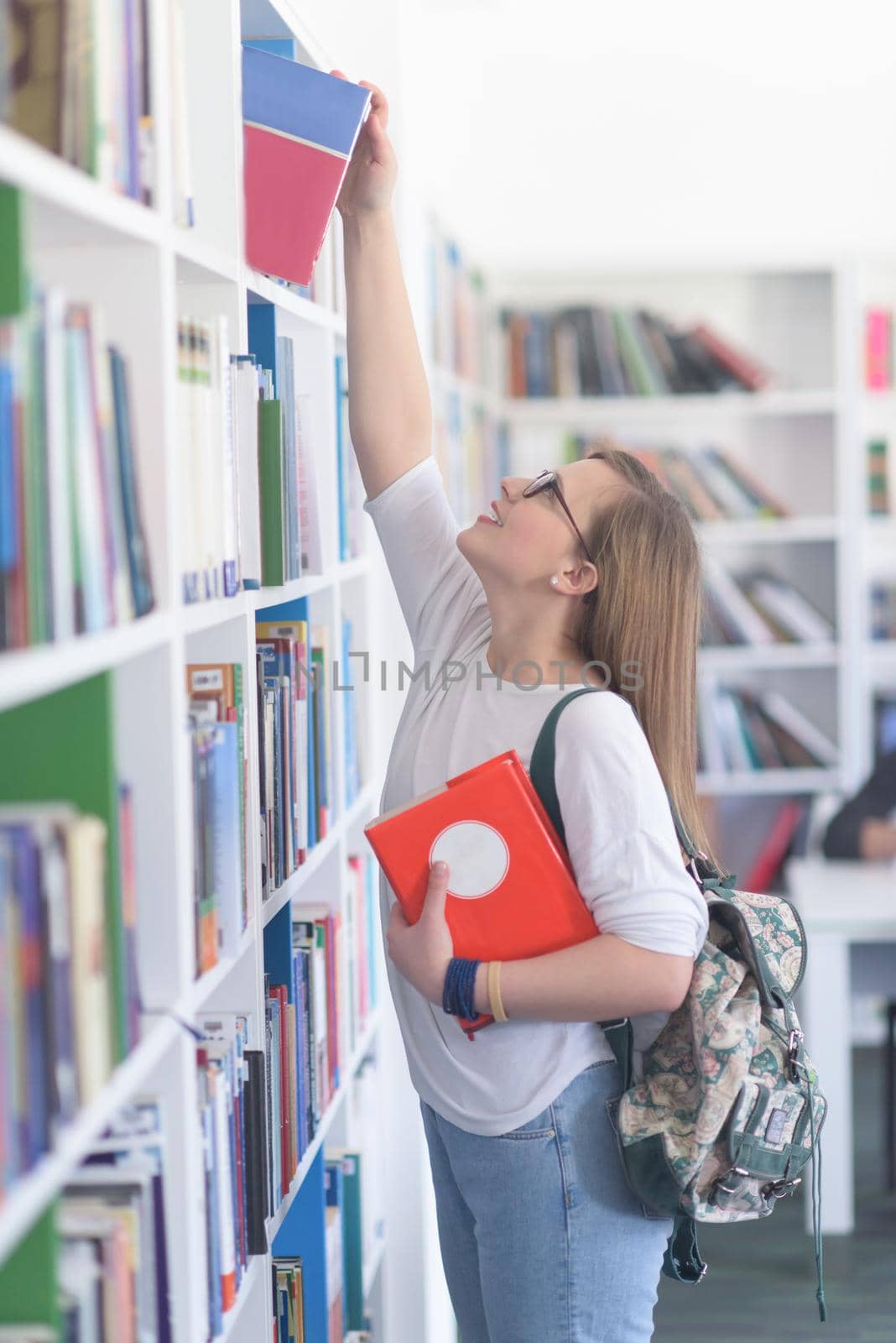 smart looking famale student girl  in collage school library selecting book to read