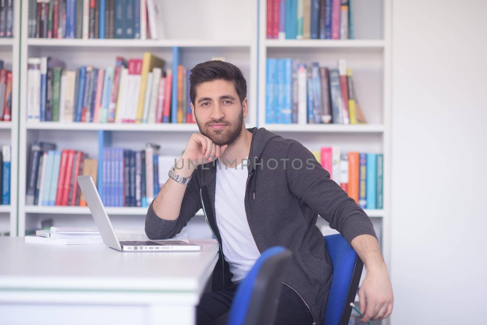 student preparing exam and learning lessons in school library, making research on laptop and browse internet