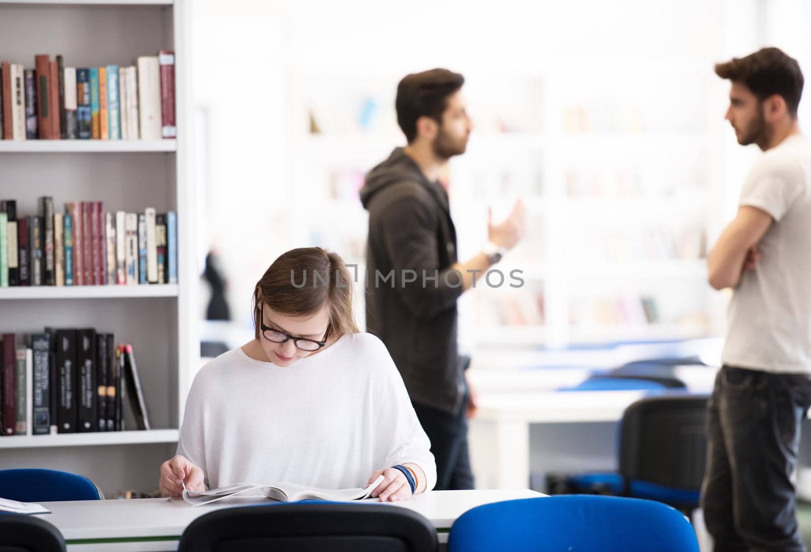 female smart looking student study in school library, group of students in background