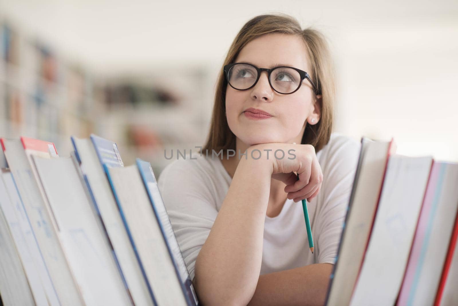 portrait of smart looking famale student girl  in collage school library,  selecting book to read from bookshelf