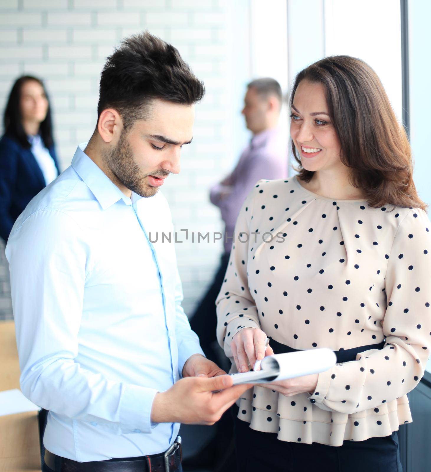 Group of happy business people discussing papers at meeting