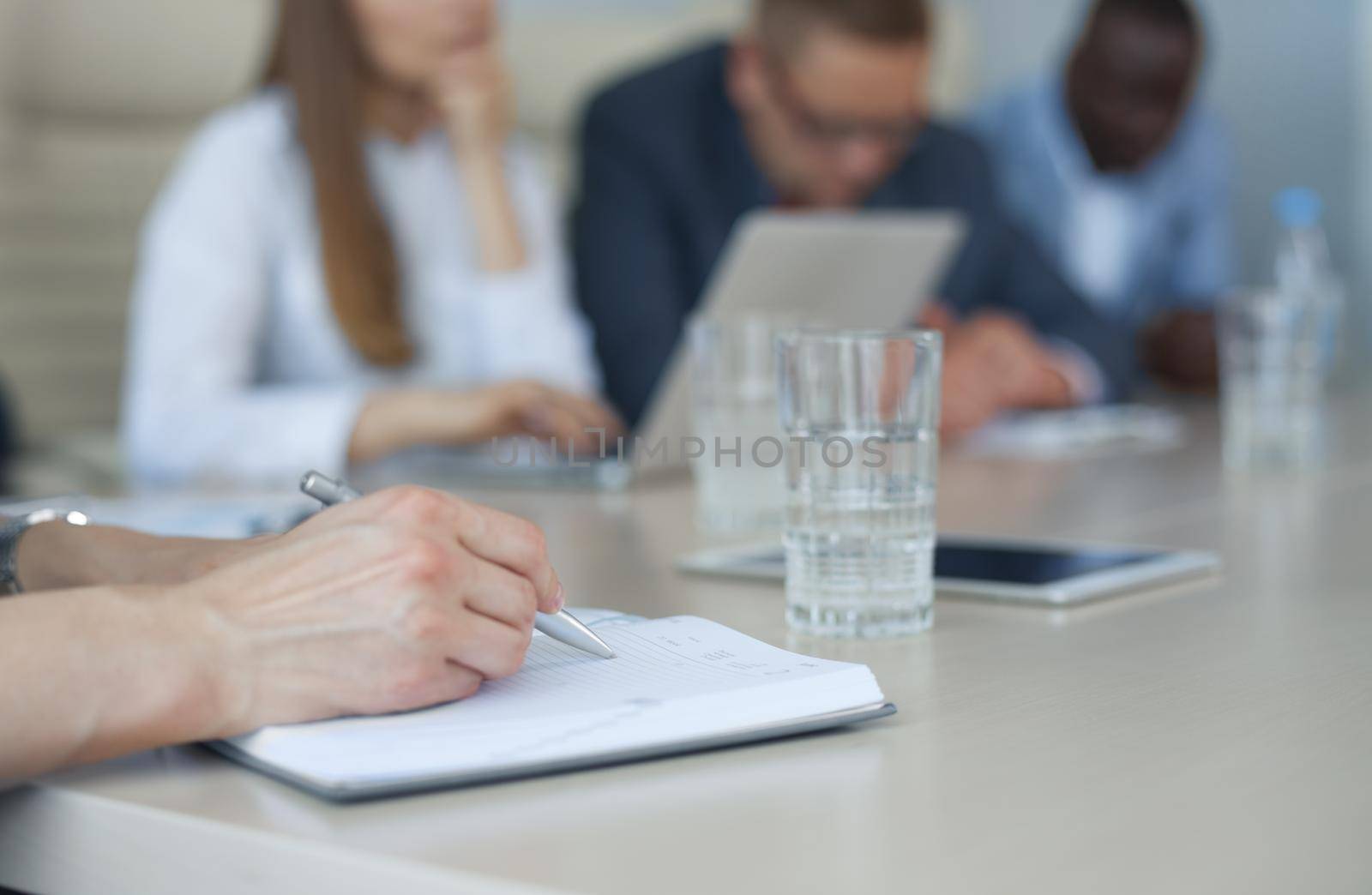 Unrecognizable business person analyzing graphs and taking notes by tsyhun