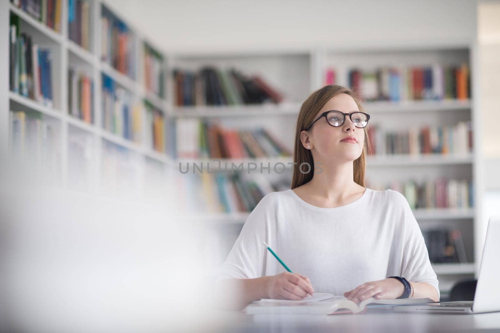 female student study in school library, using laptop and searching for informations on internet