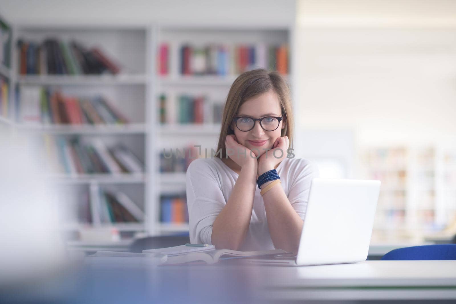 female student study in school library, using laptop and searching for informations on internet