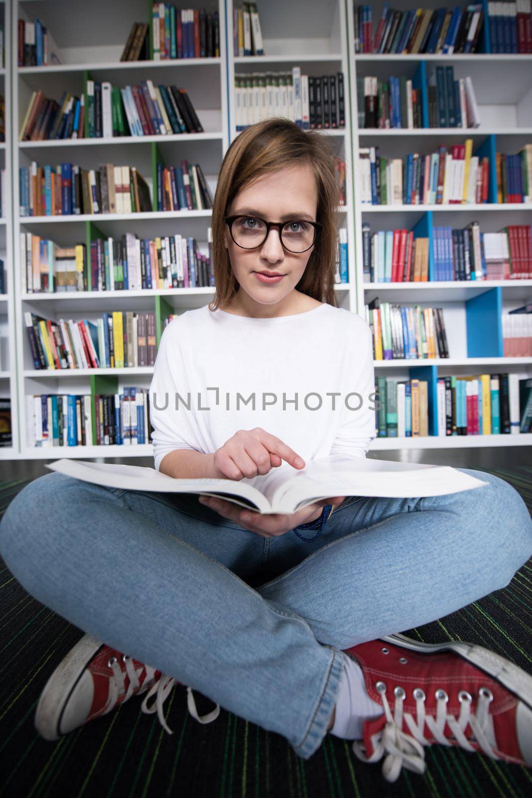 female student study in library, using tablet and searching for information’s on internet by dotshock