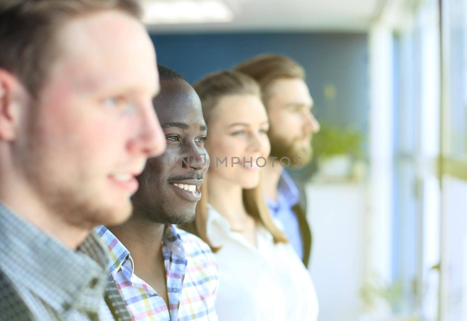 Happy smiling business team standing in a row at office