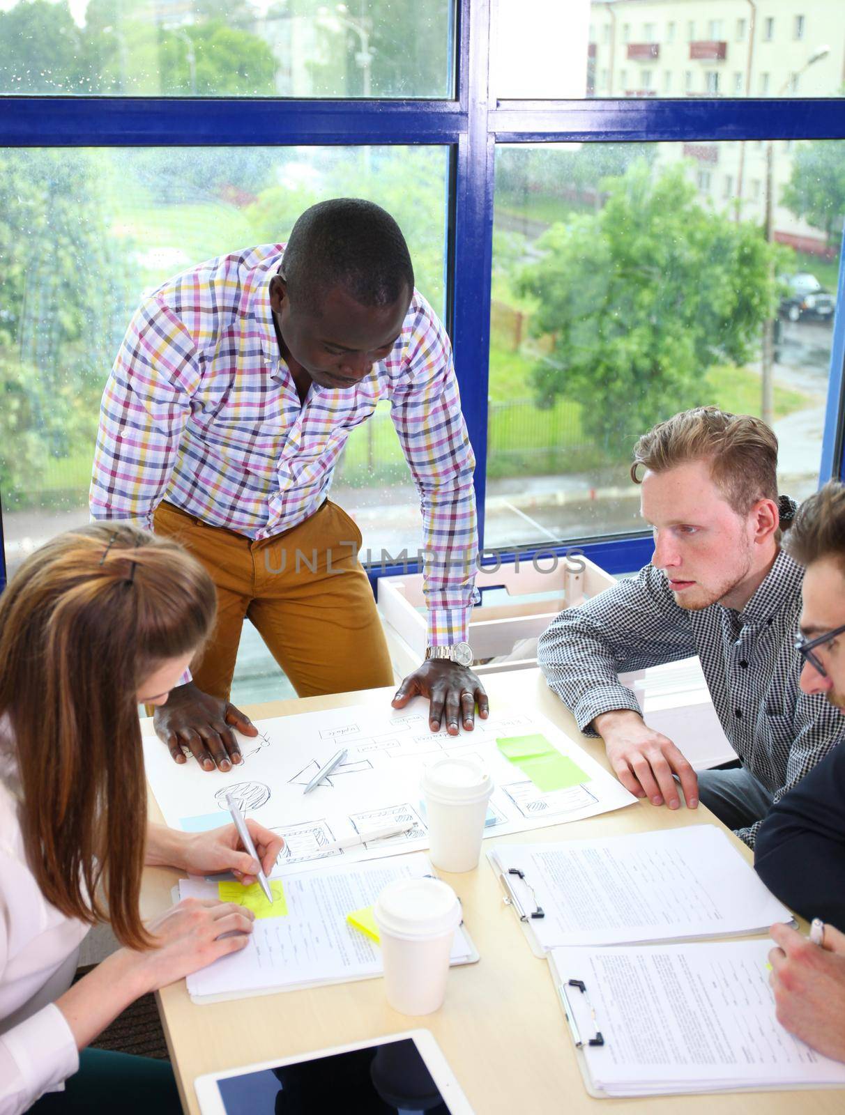 startup business team on meeting in modern bright office interior brainstorming, working on laptop and tablet computer by tsyhun