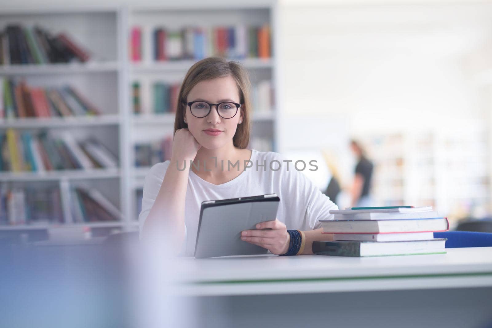 female student study in school library, using tablet by dotshock