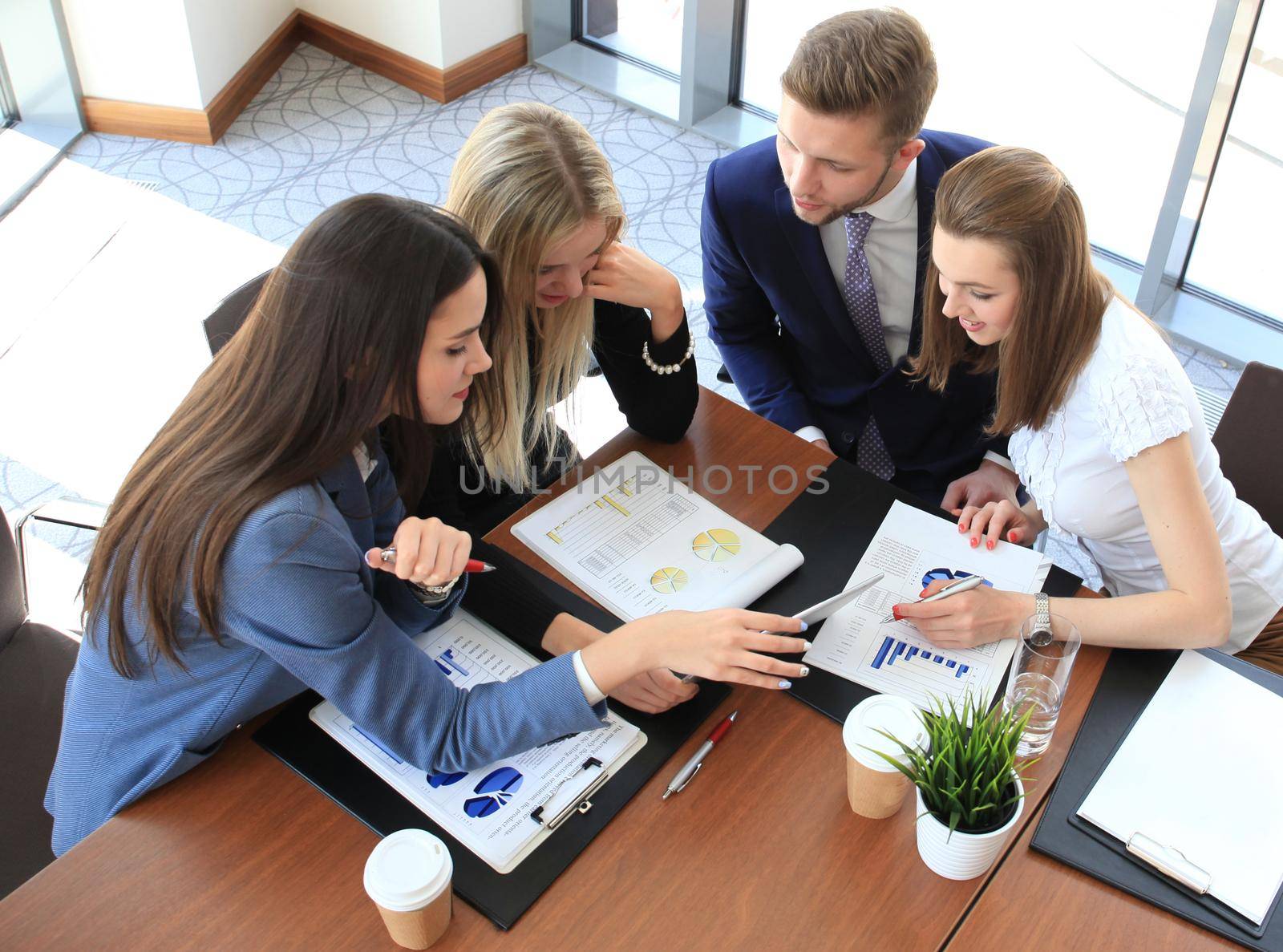 startup business team on meeting in modern bright office interior brainstorming, working on laptop and tablet computer by tsyhun