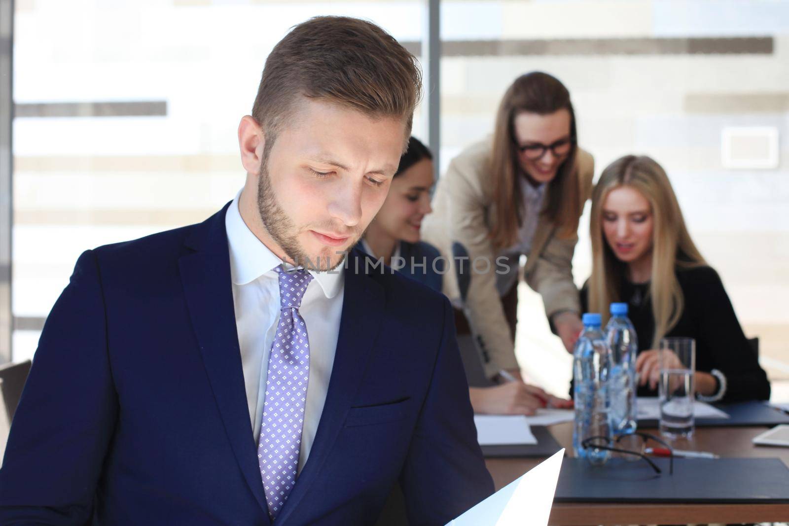 Happy smart business man with team mates discussing in the background