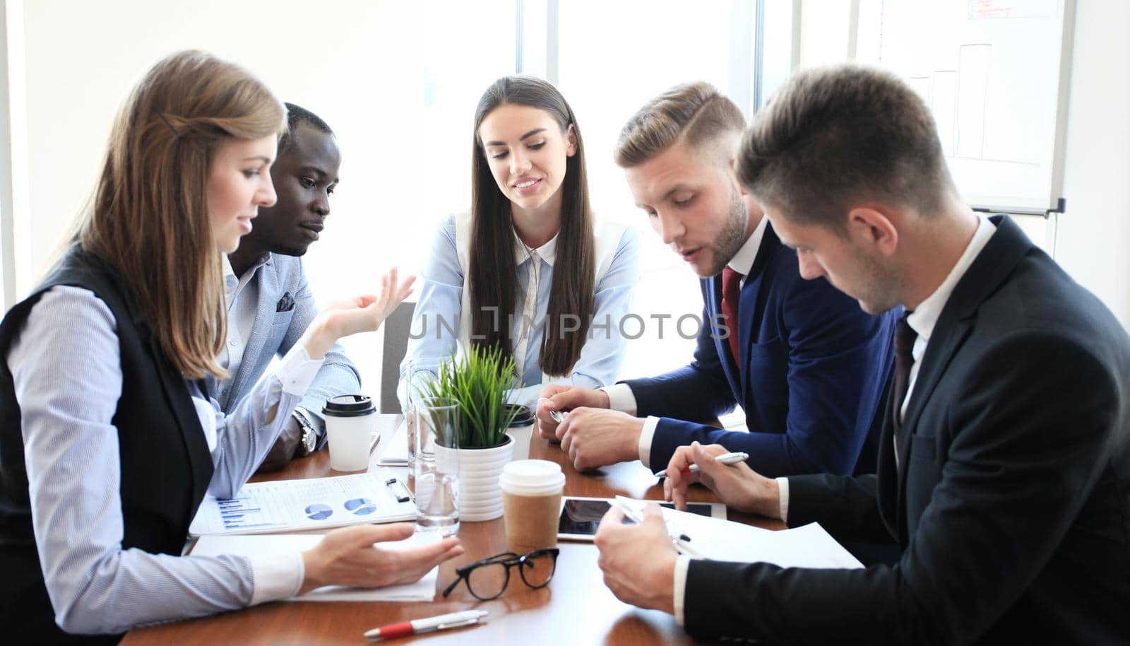 Team of business people having discussion at table in creative office.