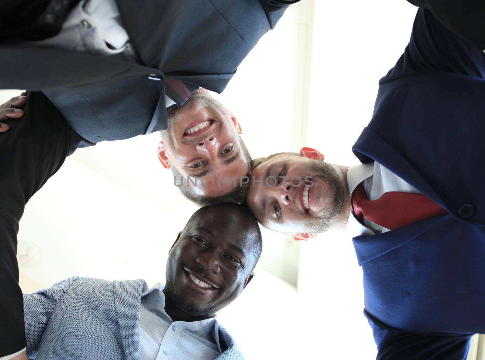 Low angle view of business people with their heads together by tsyhun