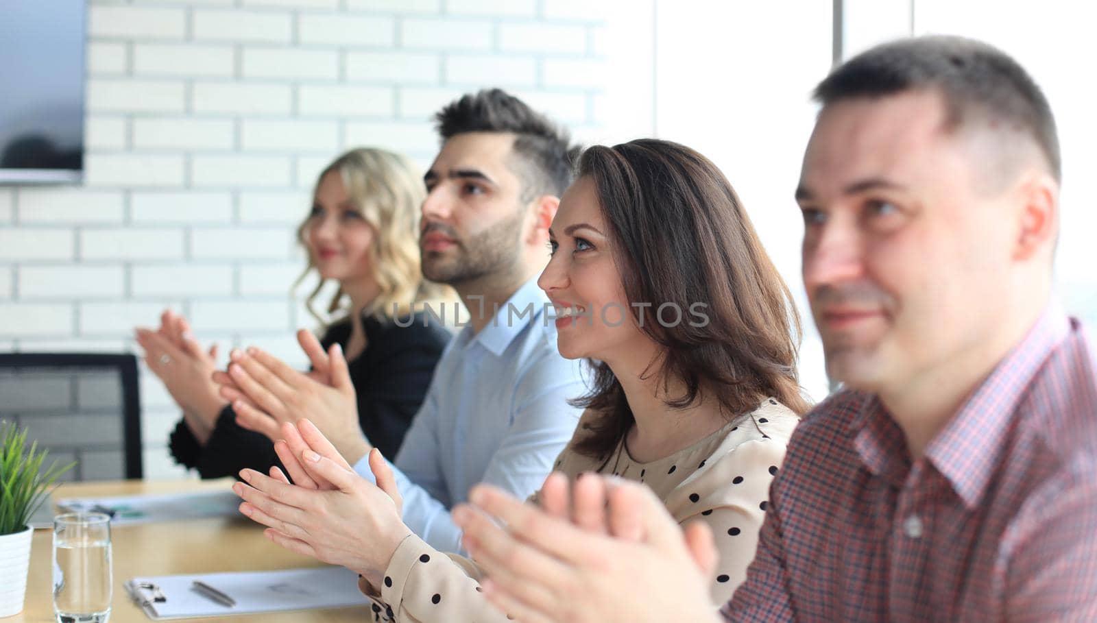 Image of business colleagues applauding in the end of the conference sitting in a line by tsyhun