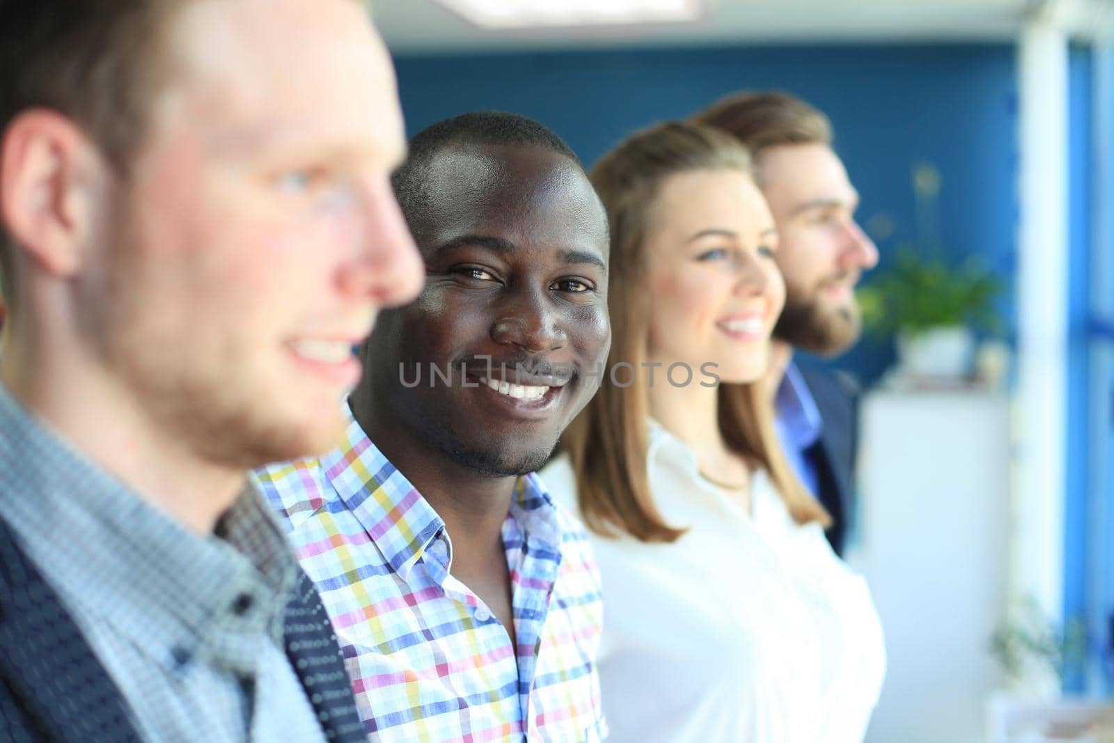 Happy smiling business team standing in a row at office