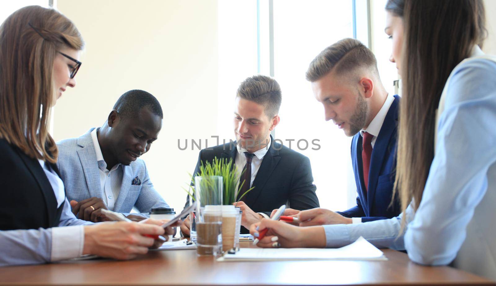 Business team discussing together business plans in office by tsyhun