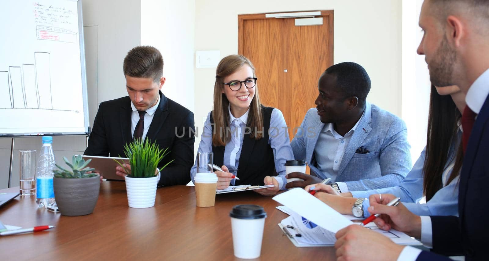 Multiethnic group of young people putting their hands on top of each other. Close up image of young business people making a stack of hands. by tsyhun