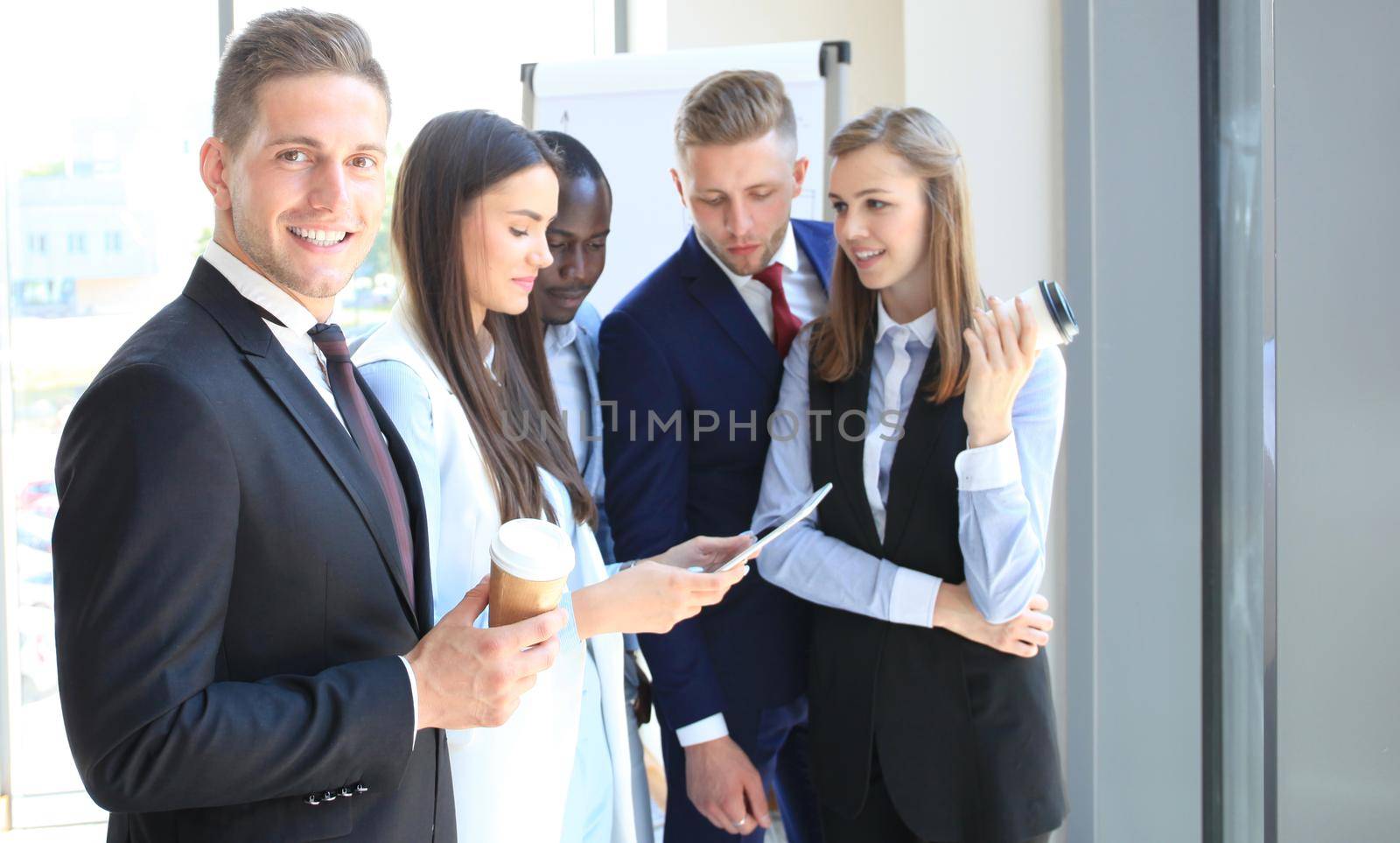 Happy smart businessman with team mates discussing in the background