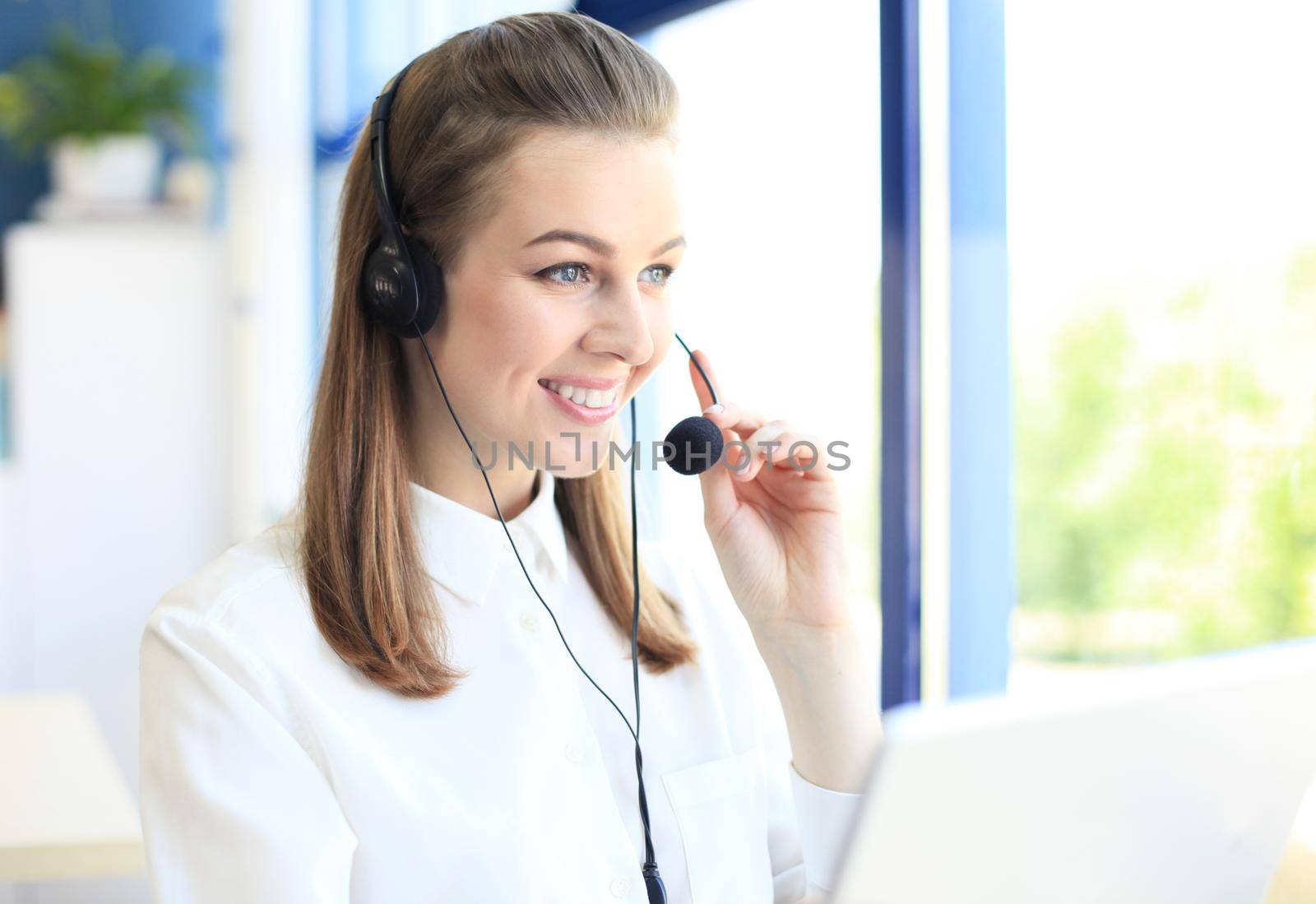 Portrait of call center worker. Smiling customer support operator at work.