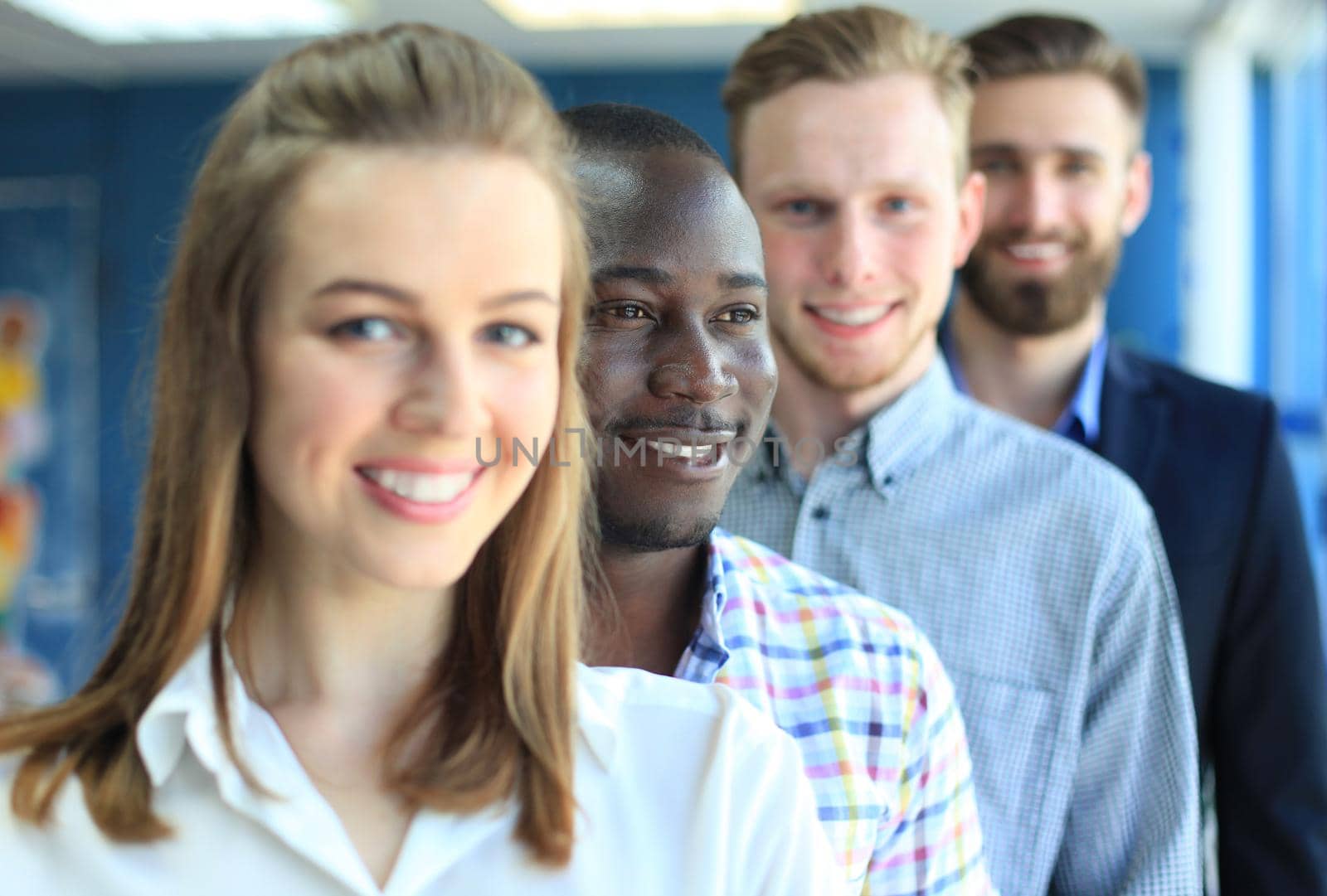 Happy smiling business team standing in a row at office by tsyhun