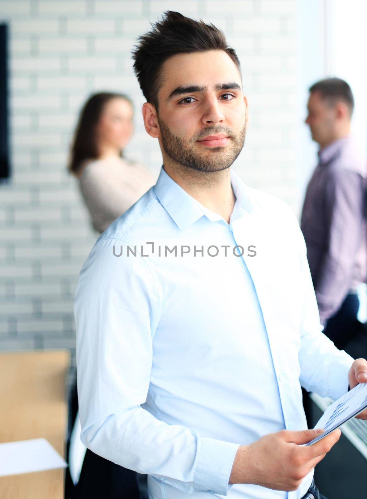 Happy smart business man with team mates discussing in the background