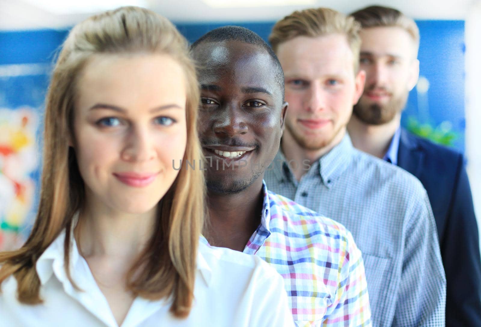 Happy smiling business team standing in a row at office