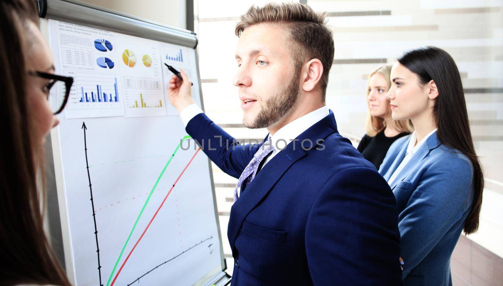 Businessman giving a presentation on flipchart. Teamwork concept