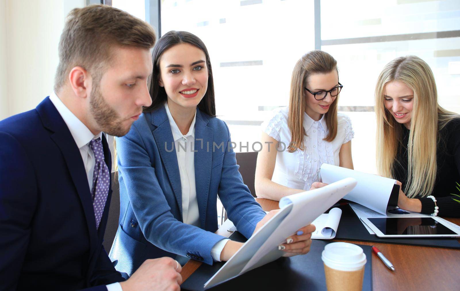 Image of four successful businesswomen looking at camera at meeting