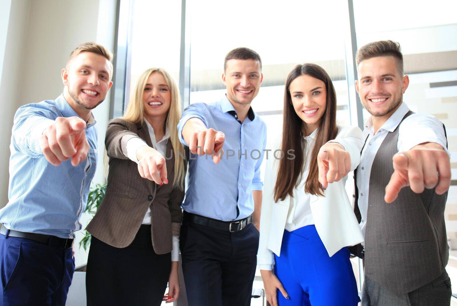 Portrait of excited young business people pointing at you by tsyhun
