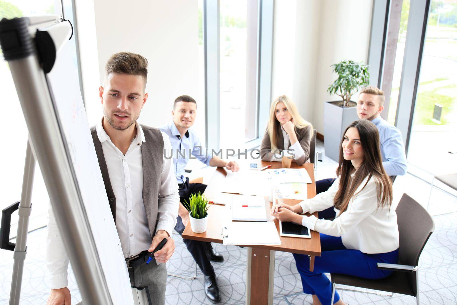 Businessman giving a presentation on flipchart. Teamwork concept