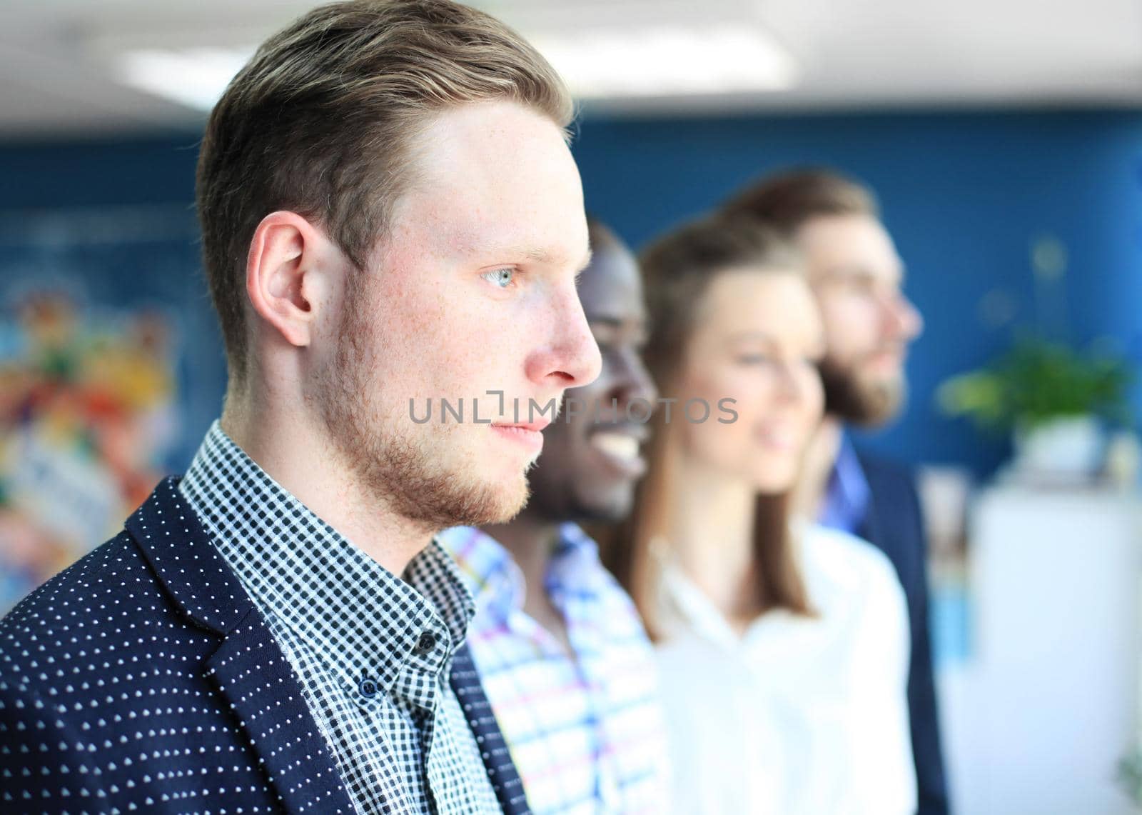 Happy smiling business team standing in a row at office