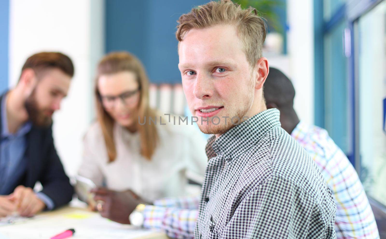 Happy smart business man with team mates discussing in the background