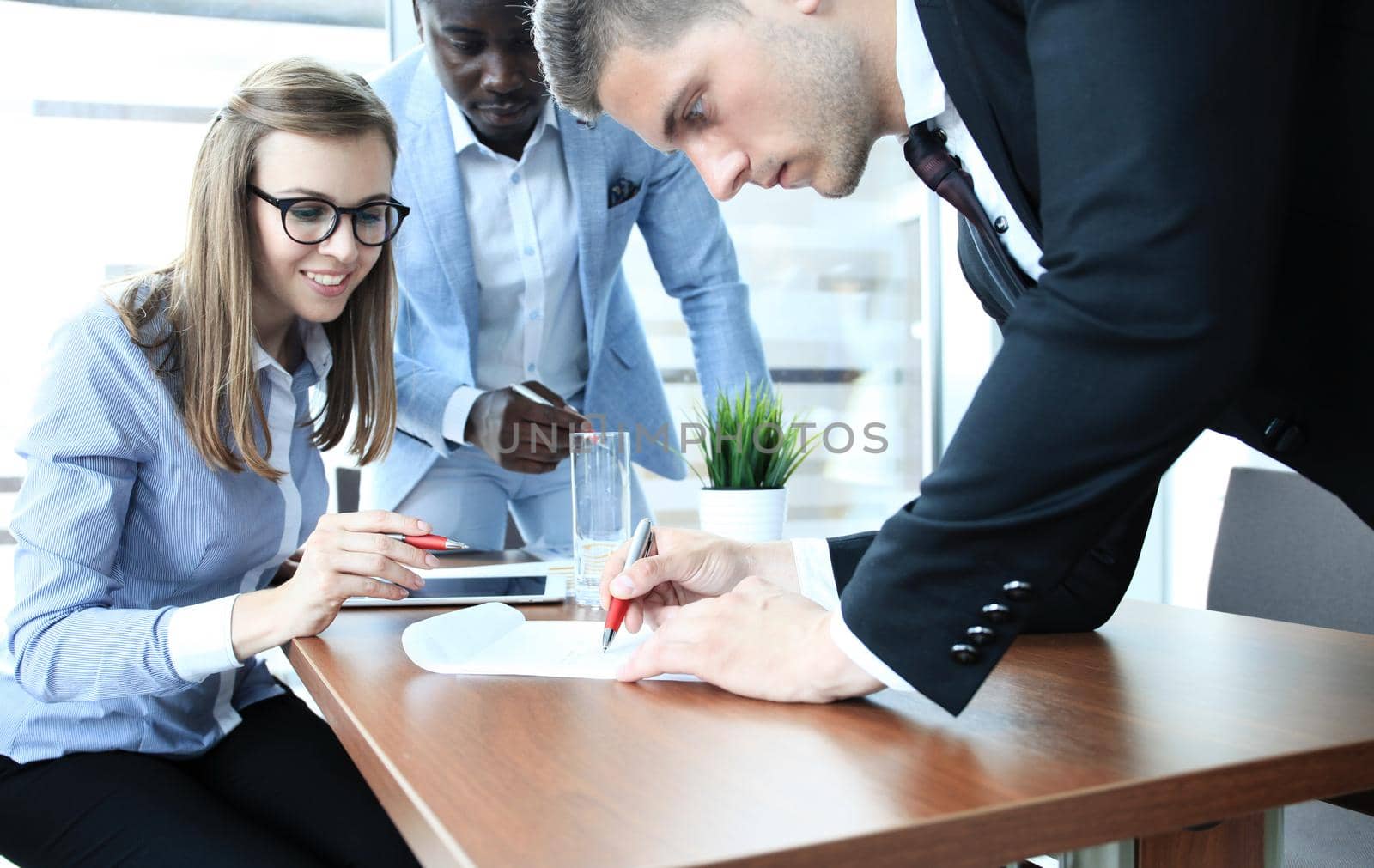 Image of business team sitting at the table and discussing a new project
