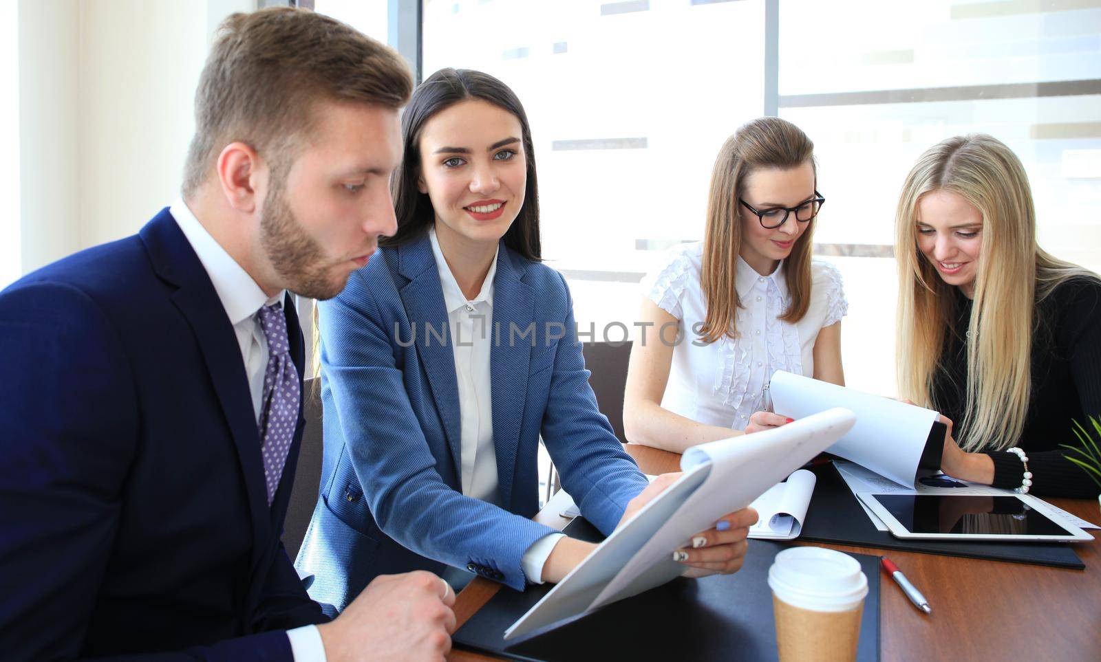 A group of business people at a meeting on the background of office. Focus on a beautiful brunet
