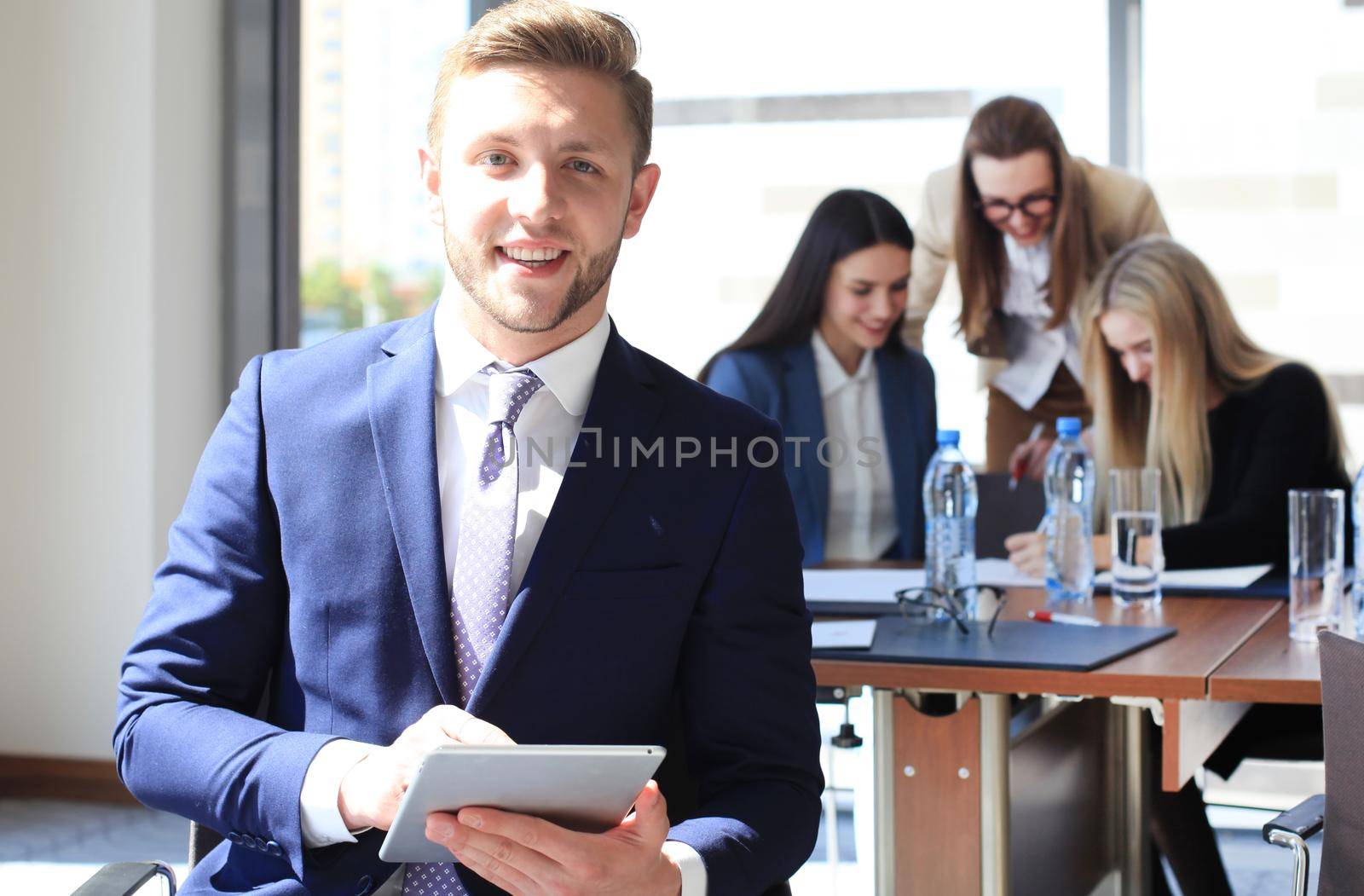 Happy smart business man with team mates discussing in the background by tsyhun