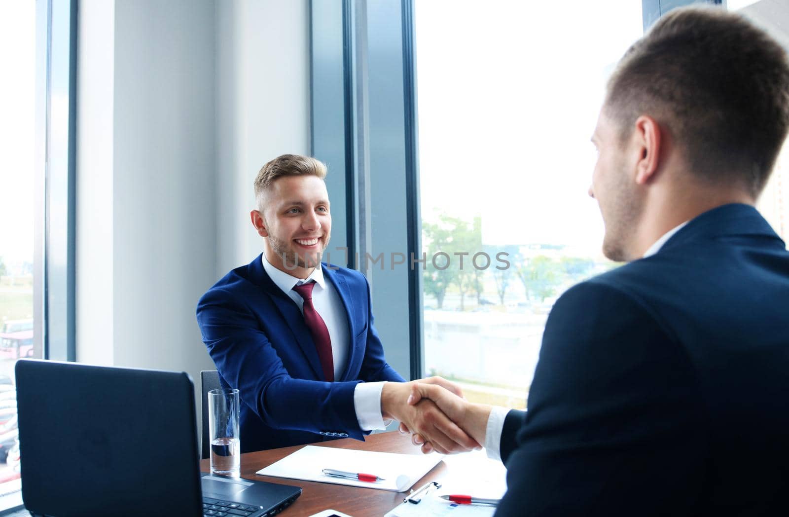 Business handshake. Two businessman shaking hands in the office.