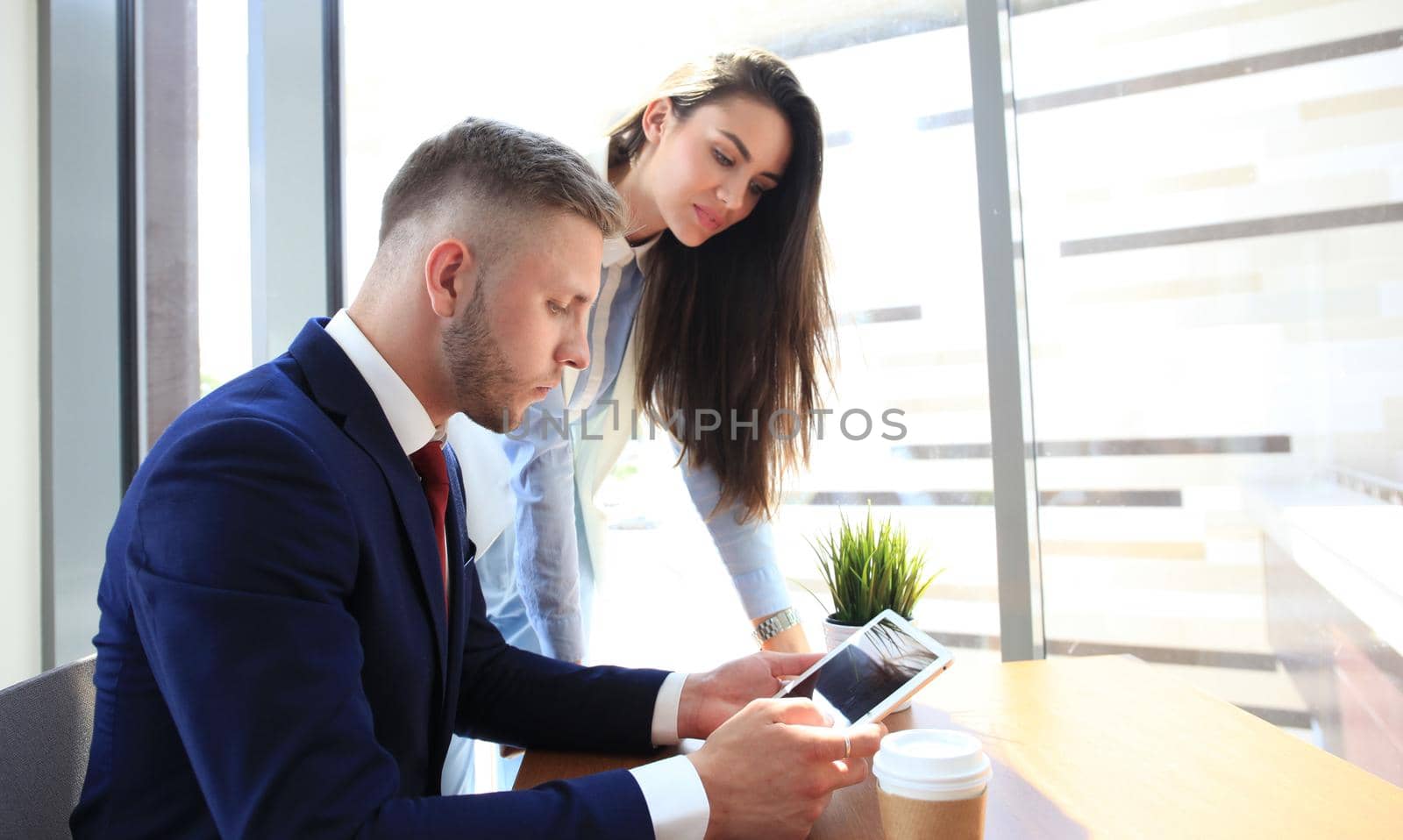 Image of two young business partners discussing plans or ideas at meeting by tsyhun