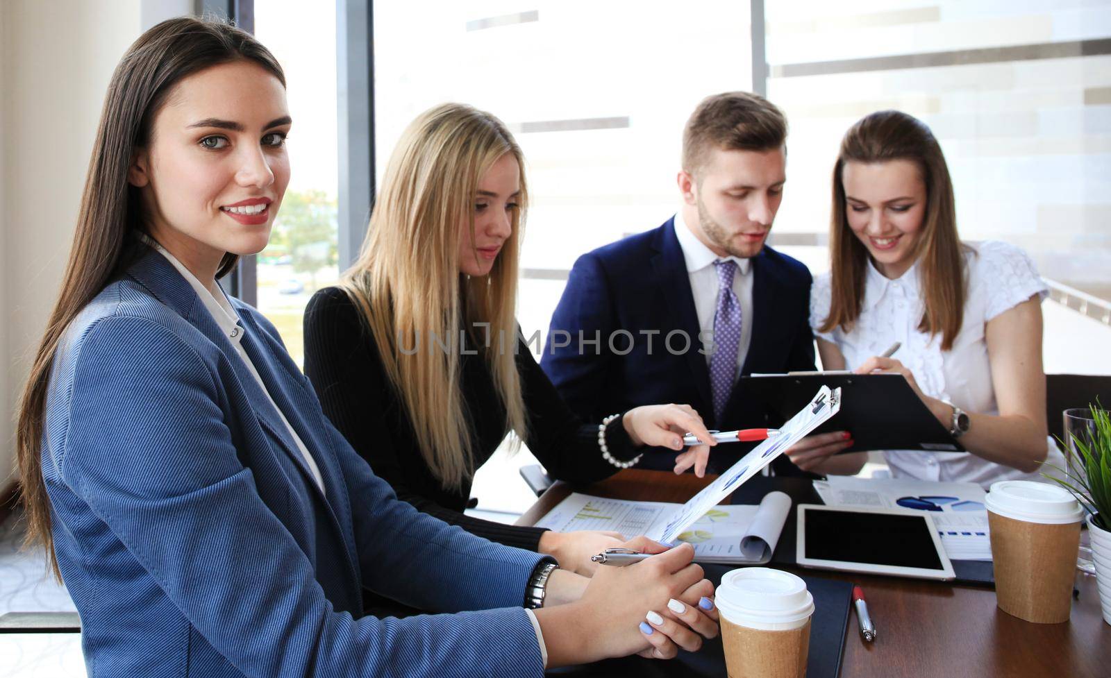 Image of four successful businesswomen looking at camera at meeting by tsyhun