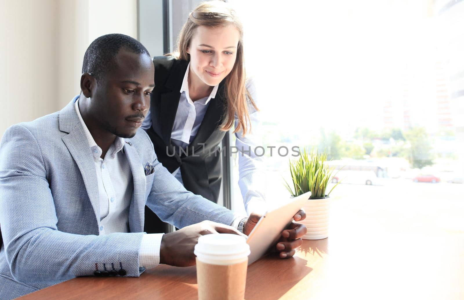 Image of two young business partners discussing plans or ideas at meeting
