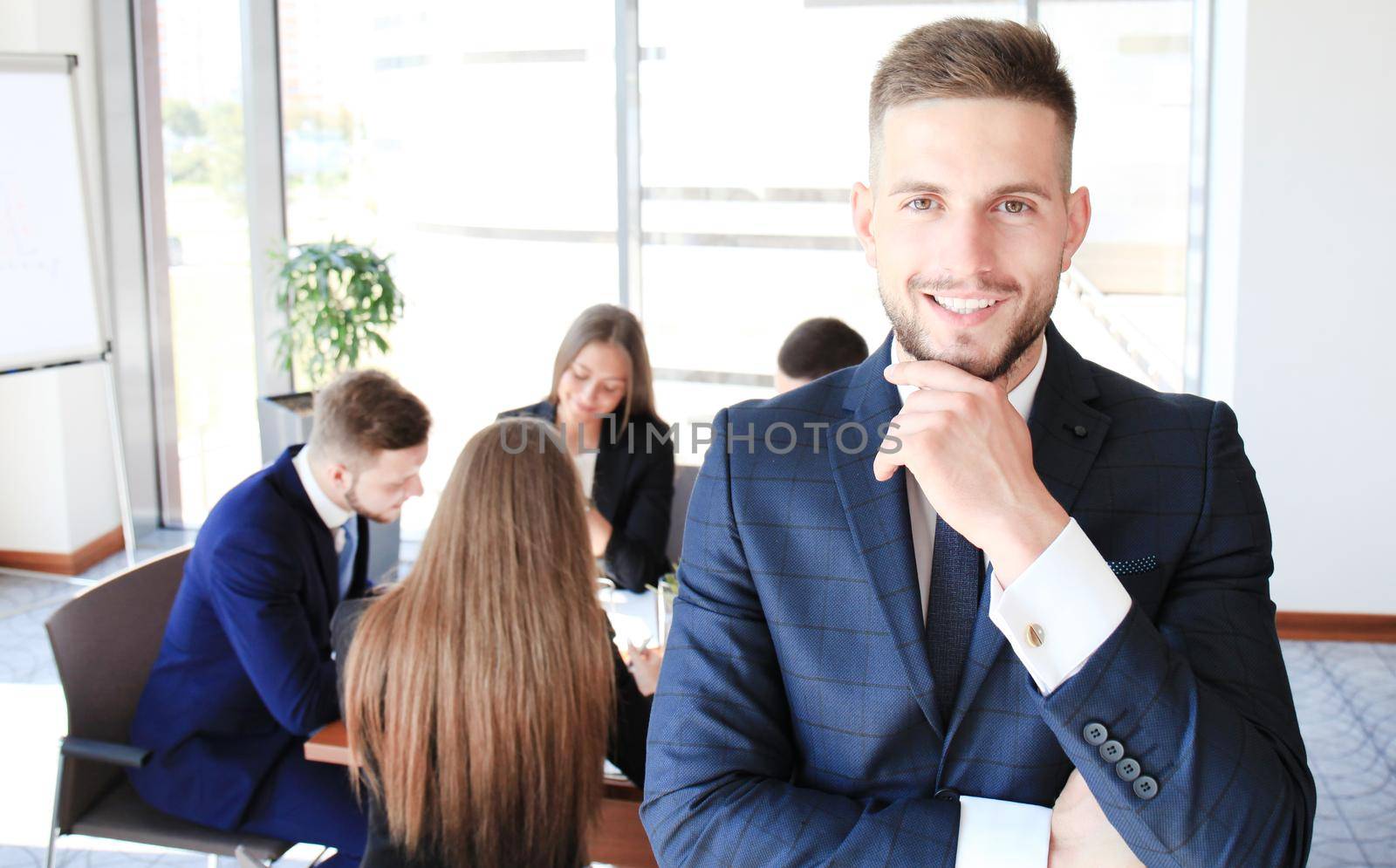 Young businessman standing in office with his collegue on the background by tsyhun