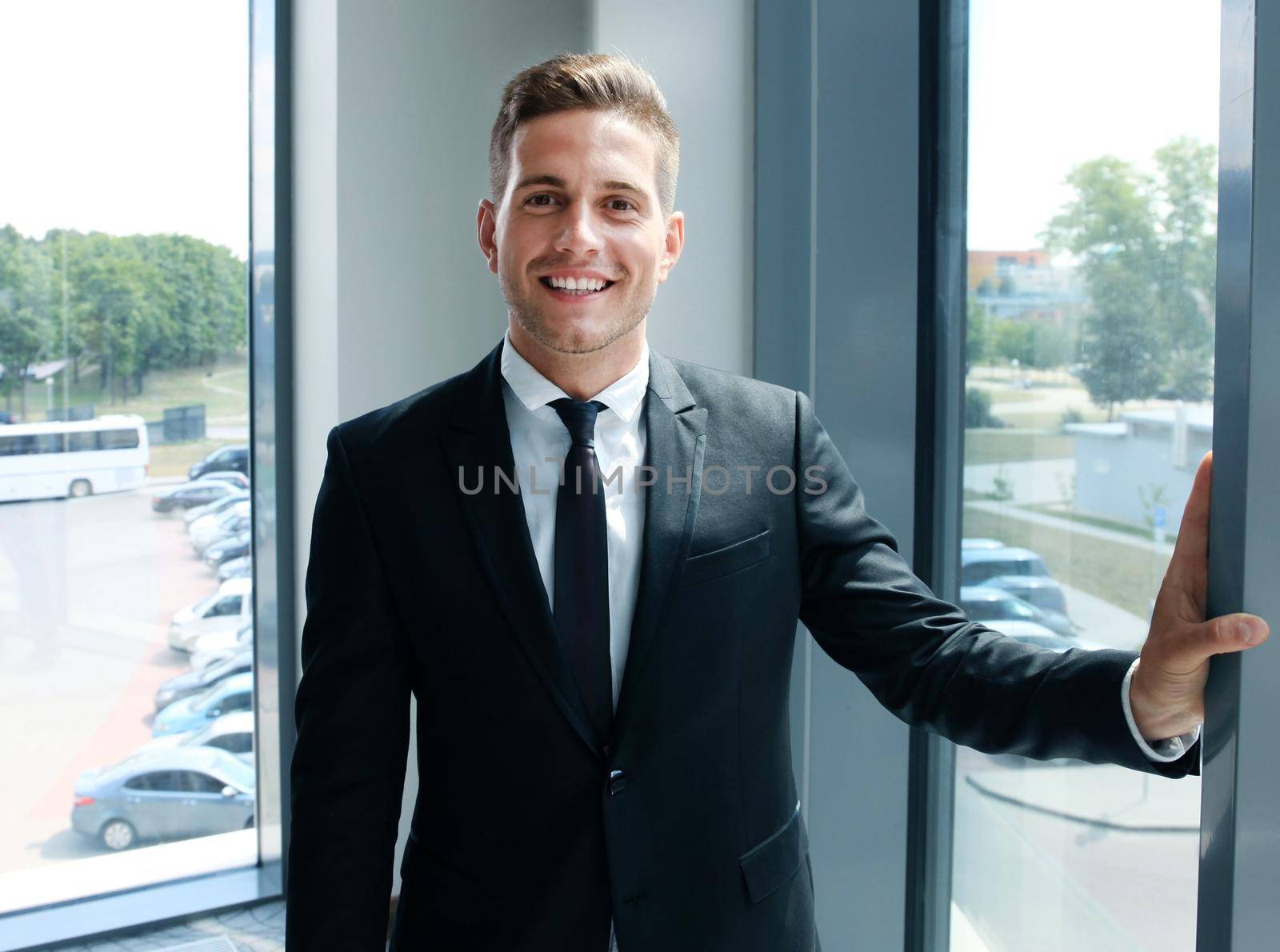 Young handsome businessman smiling in an office environment