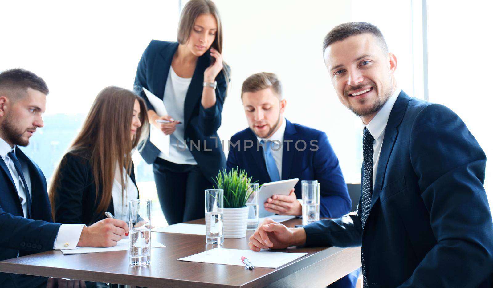 Businessman with colleagues in the background in office