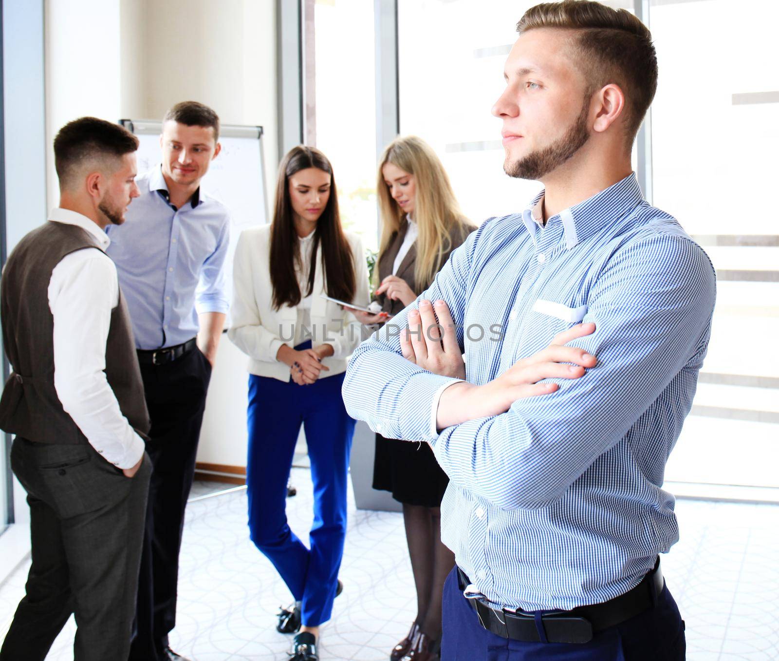 Businessman with colleagues in the background in office.