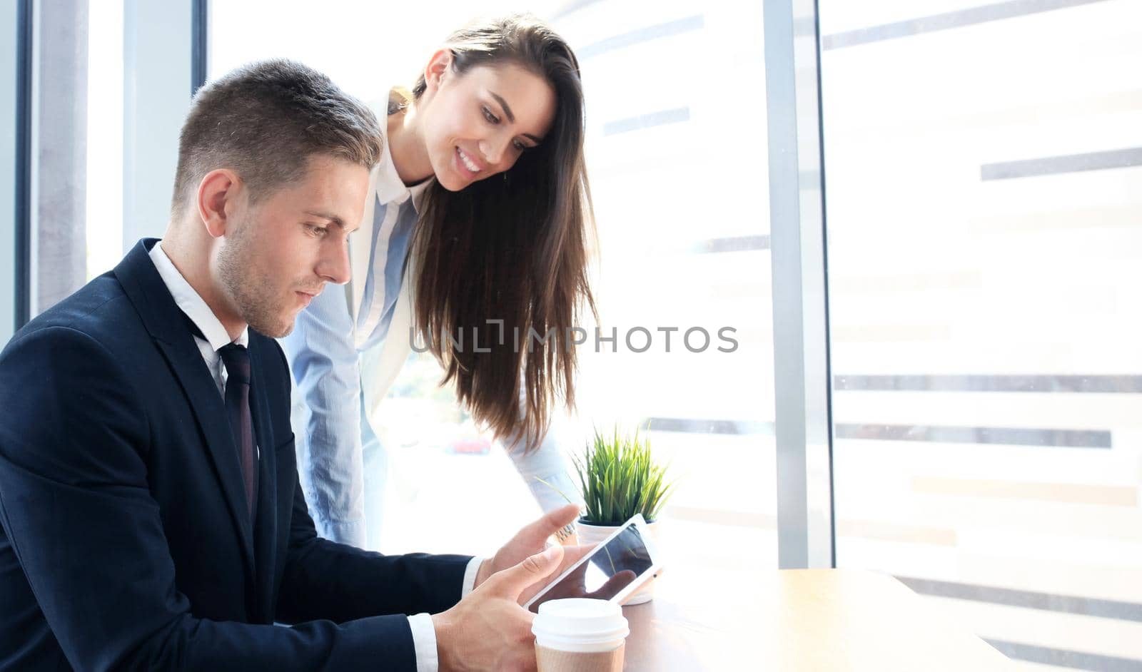 Image of two young business partners discussing plans or ideas at meeting by tsyhun