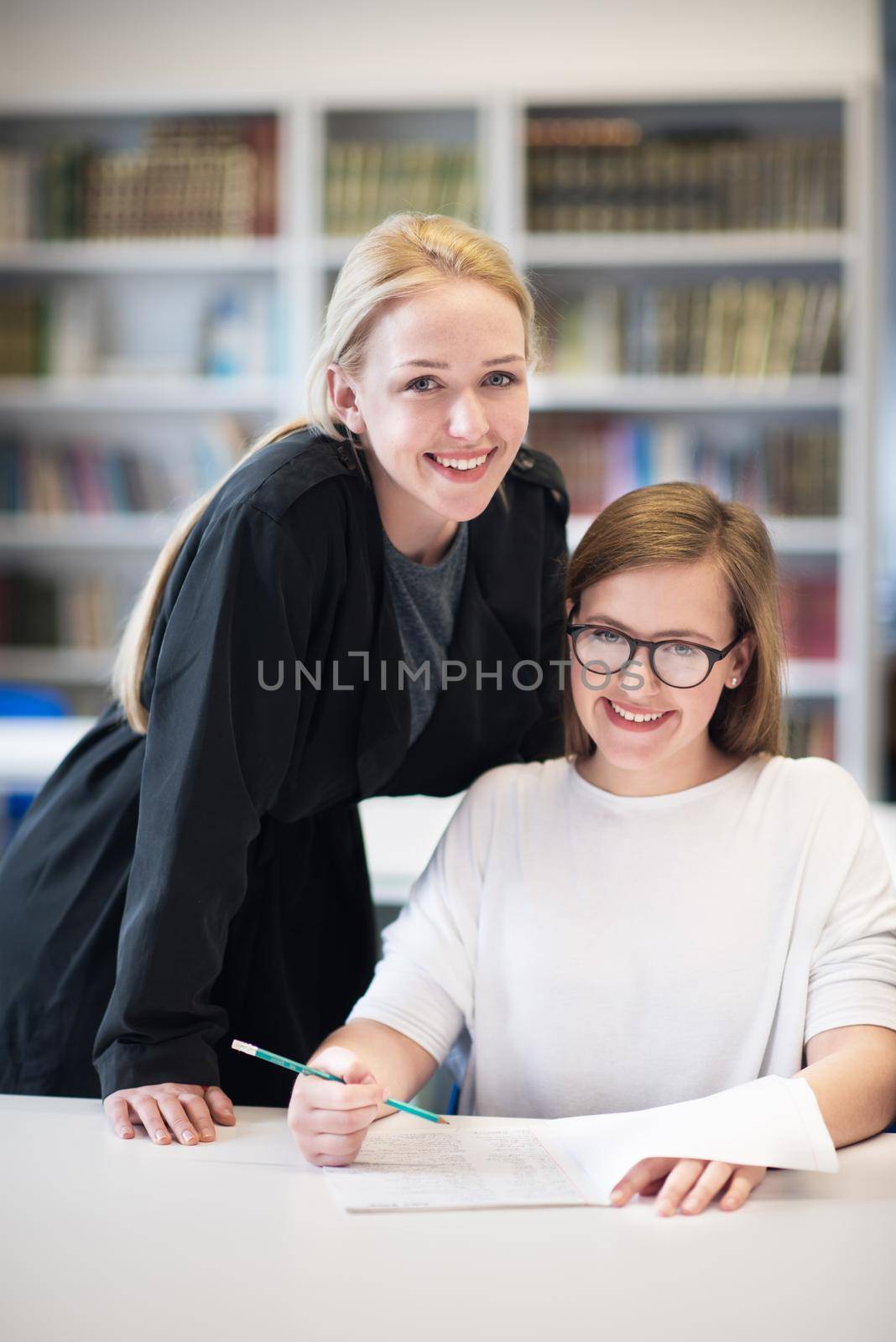 female teacher helping students on class by dotshock