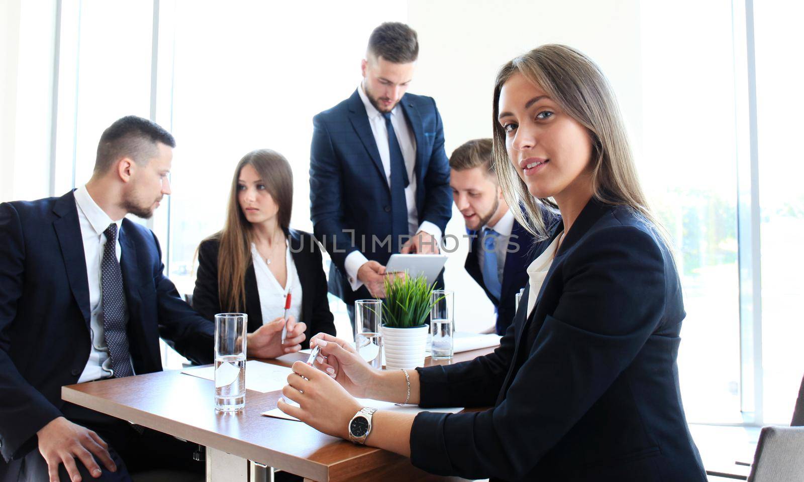 business woman with her staff, people group in background at modern bright office indoors by tsyhun